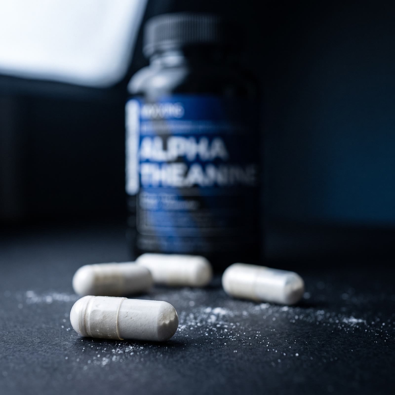 Alpha Theanine capsules on a dark surface beside the bottle